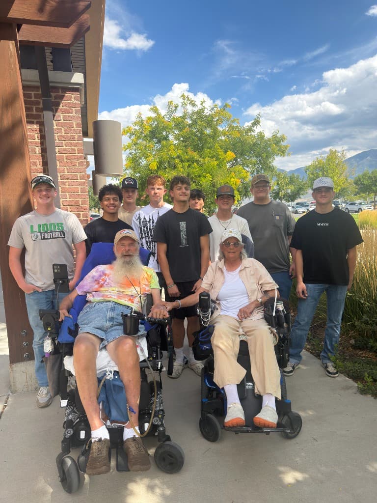 Payson Lions football players visiting two local veterans outdoors
